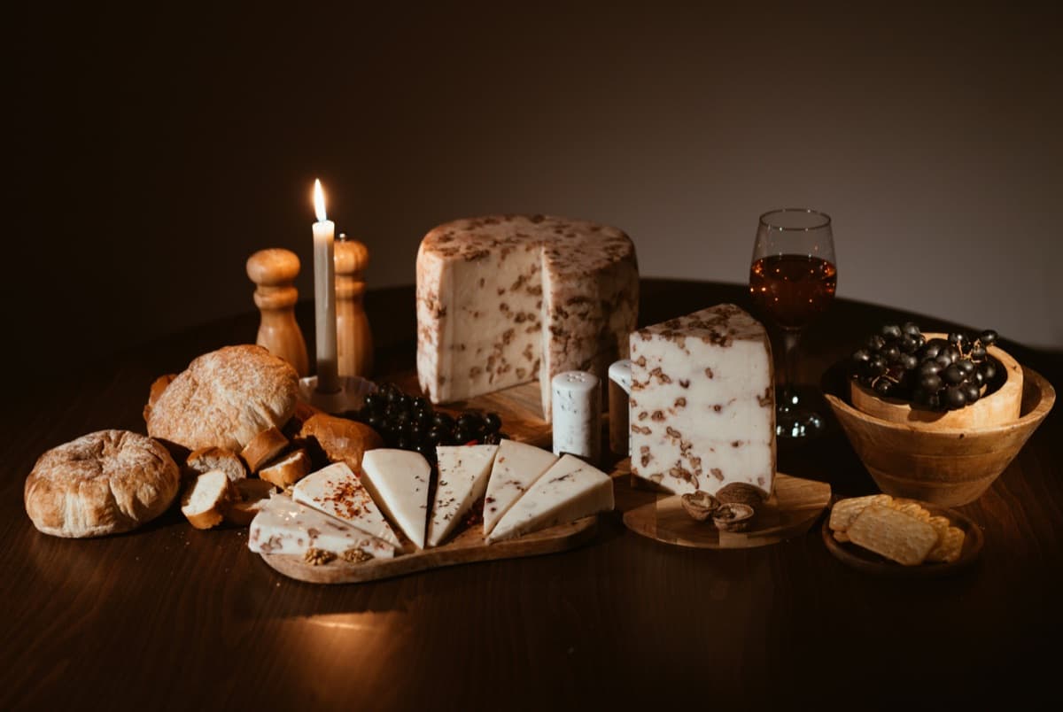 A candlelit cheese spread with a glass of wine
