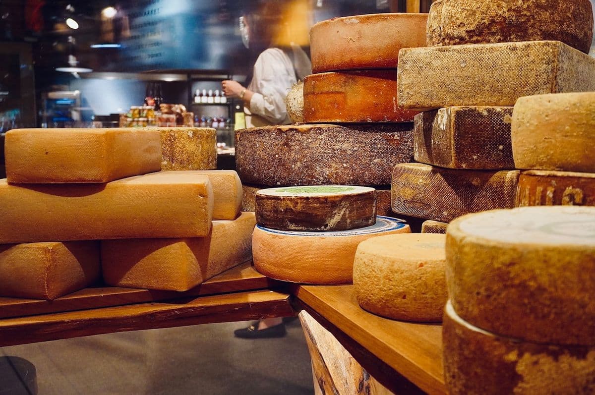 Stacked cheese wheels in a specialist shop